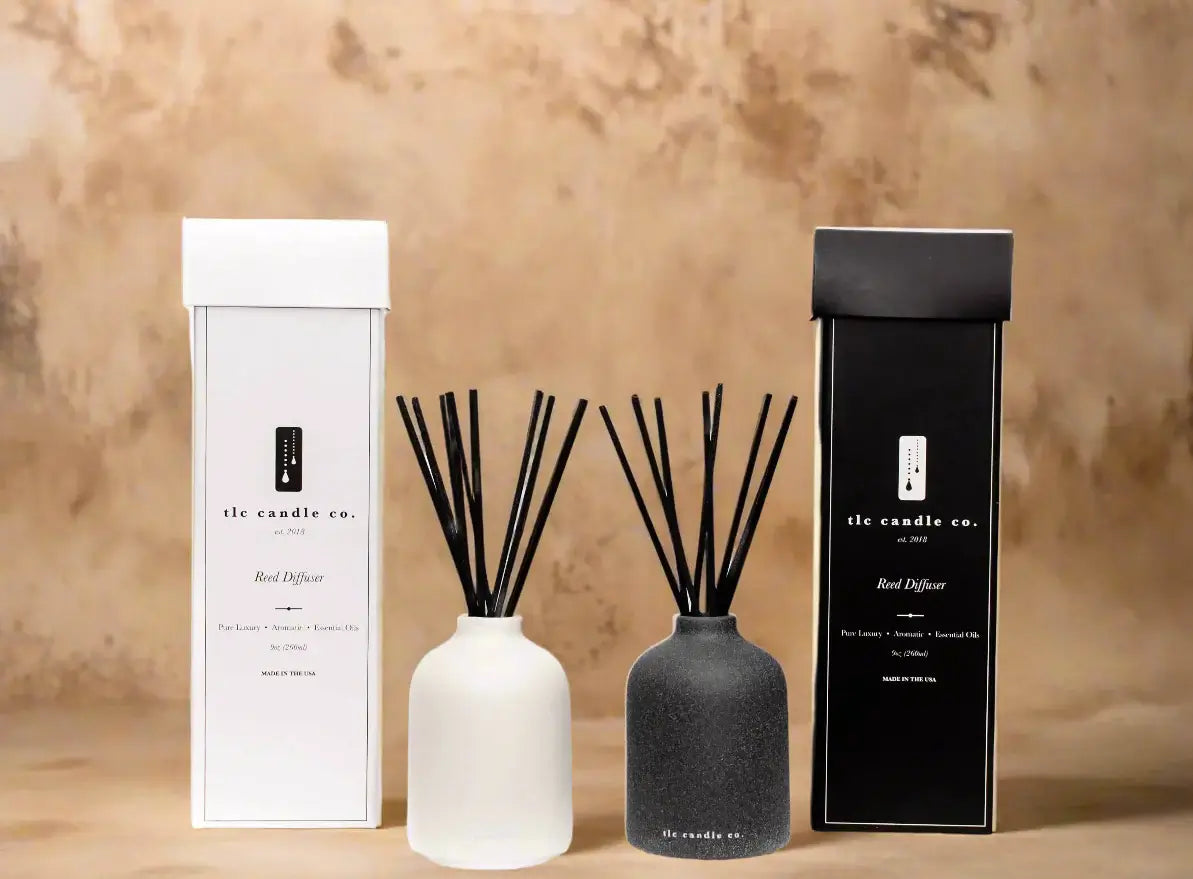 Elegant reed diffusers in white and black packaging, showcasing natural citrus scents for a refreshing ambiance.