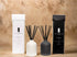 Elegant reed diffusers in white and black packaging, showcasing natural citrus scents for a refreshing ambiance.